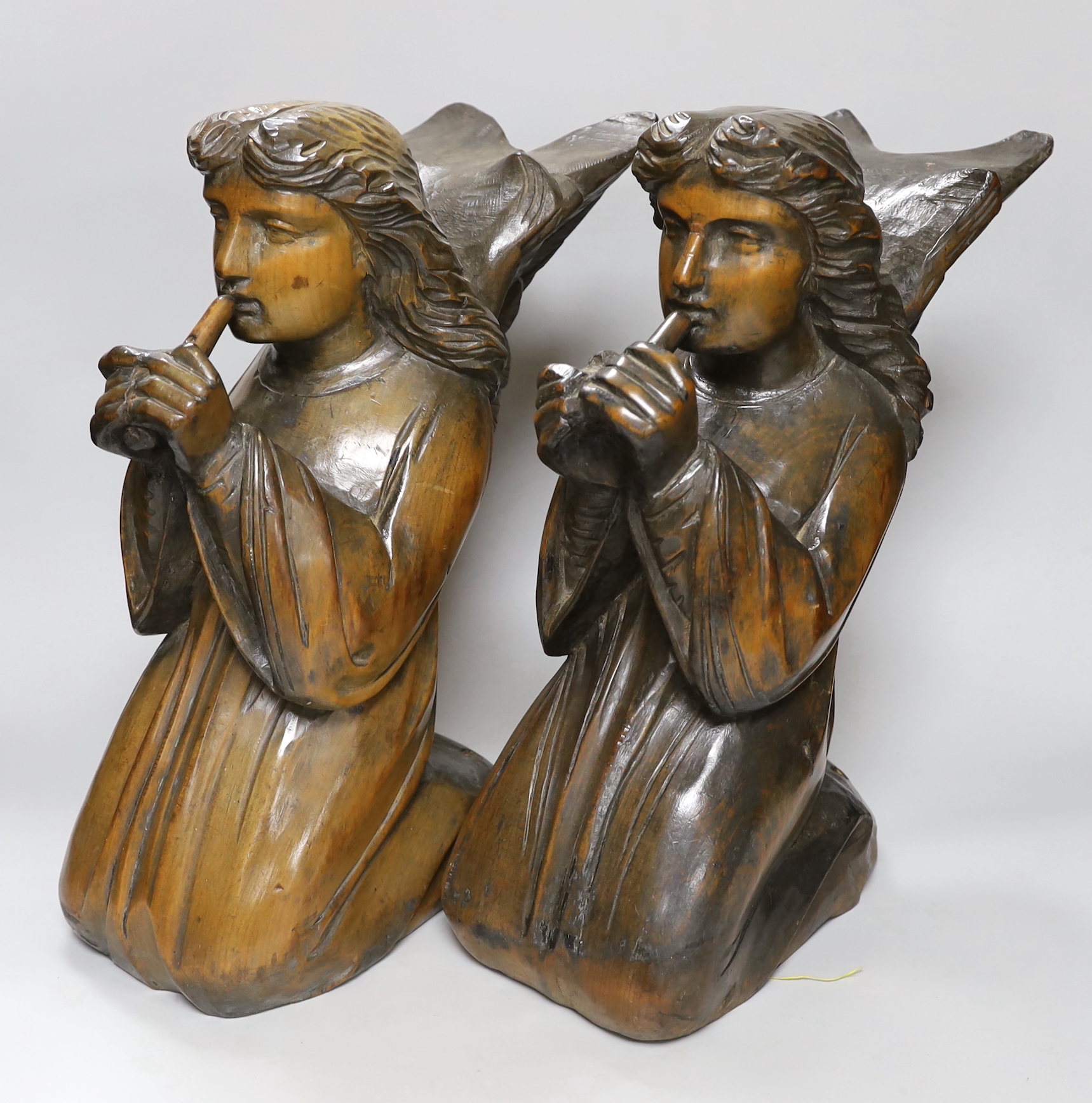 A pair of carved pine angels playing recorders, height 40cm